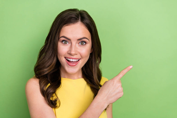 Portrait of attractive cheerful wavy-haired amazed girly girl showing copy blank space isolated over bright green color background - Fotografie, Obrázek