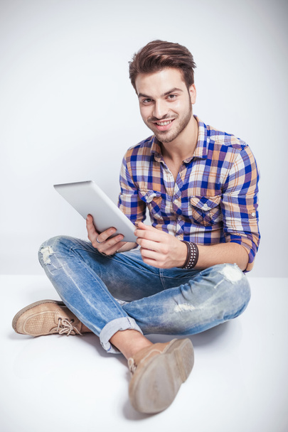 Happy young man holding a tablet pad computer - Photo, Image