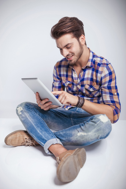  タブレット コンピューターを使用しながら座っている若者のファッション男性 - 写真・画像