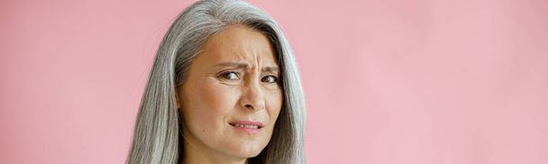 disgustoso grigio dai capelli asiatico donna tiene sonic facciale pulizia spazzola in studio - Foto, immagini