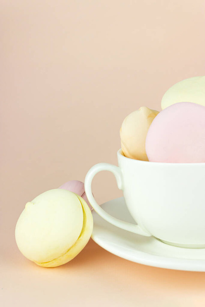 Kolorowe pianki wygląda jak makaroniki, słodki deser w porcelanowej filiżance białej kawy kubek - Zdjęcie, obraz