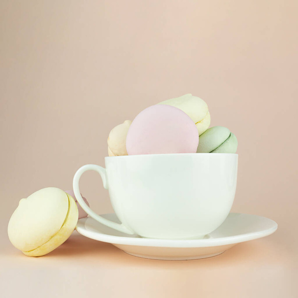 Традиційний смачний солодкий зефір виглядає як макарони в порцеляновій чашці з білою кавою
 - Фото, зображення