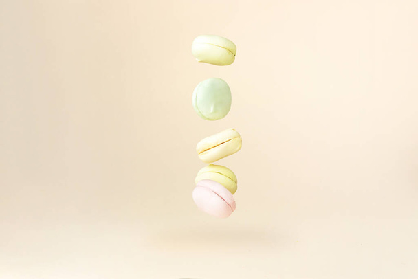La caída de deliciosos malvaviscos dulces coloridos se parece a los macarrones sobre un fondo claro. Concepto de congelación en movimiento - Foto, Imagen