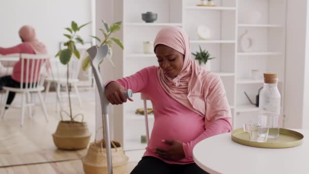 Pregnant African Lady Holding Crutches Touching Belly Feeling Pain Indoor - Footage, Video