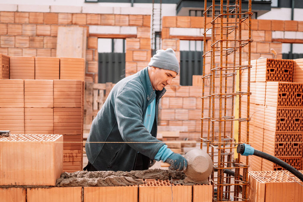 worker, bricklayer and mason working with bricks and building interior walls of house - 写真・画像