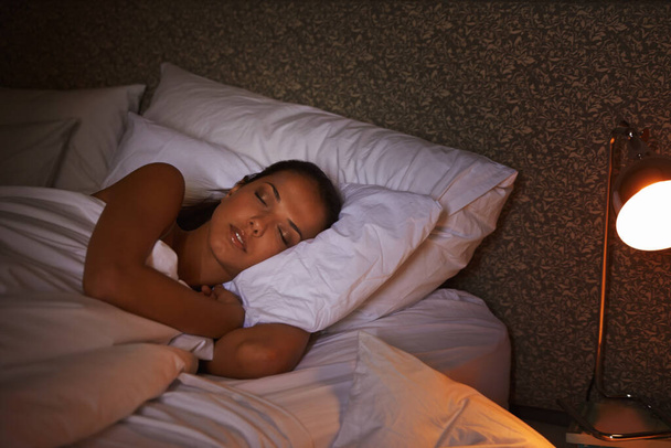 Cómodo como un insecto. Foto de una atractiva joven hembra durmiendo en la oscuridad. - Foto, imagen