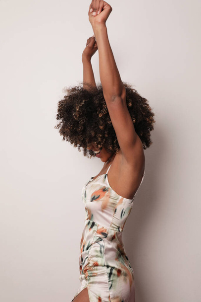Vertical photo of African American woman smiling dancing over white background. - Foto, imagen