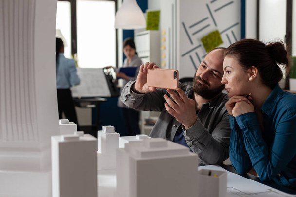 Architekten bei Teamarbeit beim Betrachten mobiler Inhalte auf dem Smartphone - Foto, Bild
