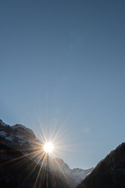 Wasserauen, Appenzell, Szwajcaria, 26 stycznia 2022 Słońce znika za majestatycznymi Alpami - Zdjęcie, obraz