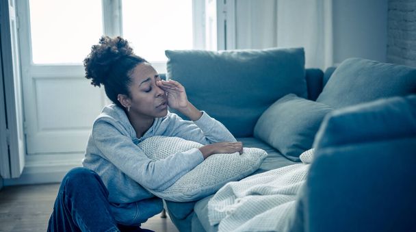 Depressed young attractive african american woman lying on sofa at home feeling sad tired and worried suffering depression stress and anxiety in mental health, loneliness and isolation concept. - Zdjęcie, obraz