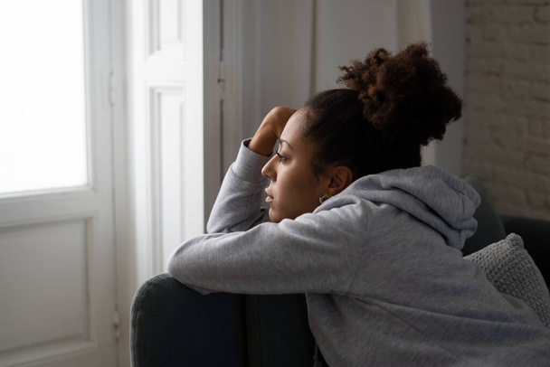 Young devastated depressed african american woman crying feeling sad, hurt suffering depression in sadness and emotional pain. Mental health in young people, bullying suicide and heartbroken concept. - 写真・画像