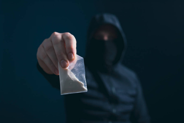 Hand of addict man holding a dose of cocaine or heroine. Concept of drug dealer, drug trafficking, crime, addiction and sale. - Photo, image