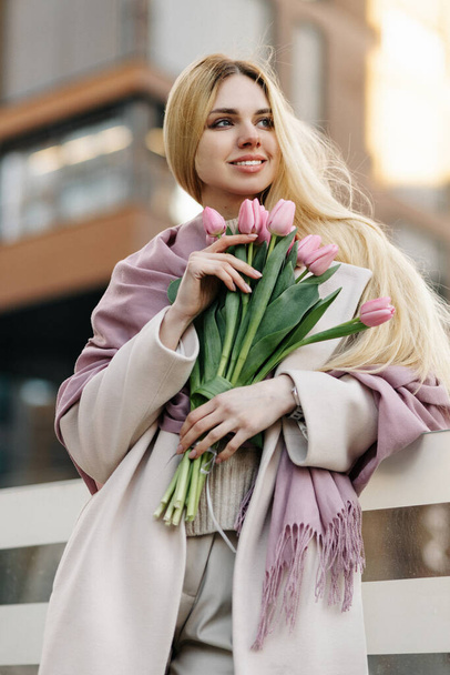 Mooi meisje met een boeket roze tulpen - Foto, afbeelding