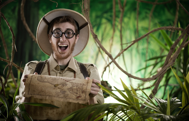 Explorer in jungle holding map - Photo, Image