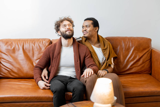 mâle gay couple parler sur un canapé à la maison - Photo, image