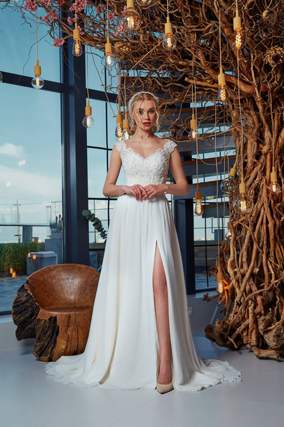 Sexy beautiful blonde woman pretty bride wedding big day marriage ceremony in summer garden wearing long silk and lace white dress bright makeup hairstyle pure love interior. - Foto, imagen