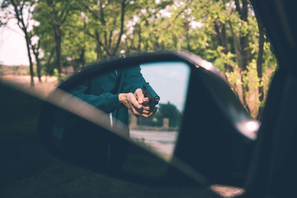 man hand gun in car in nature - Photo, image