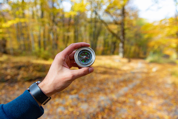 man hand compass with autumn  forest  - Fotoğraf, Görsel