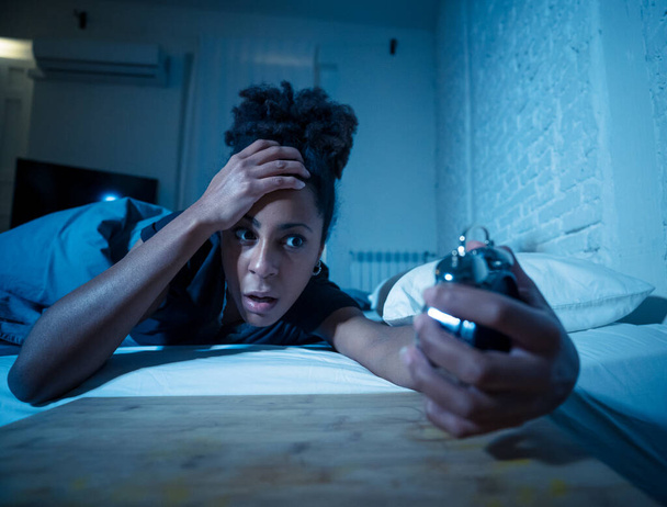 Young beautiful afro american woman at home lying in bed late at night trying to sleep suffering insomnia sleeping disorder or scared on nightmares looking stressed and worried Mental health concept. - Foto, afbeelding