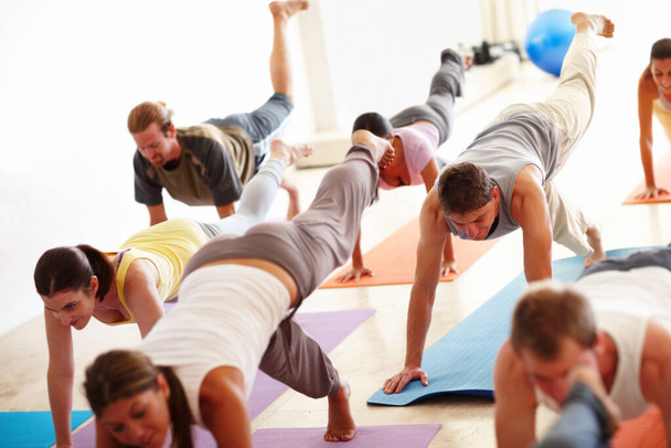 Advanced yoga techniques. A group of people working out on yoga mats. - Foto, Imagem