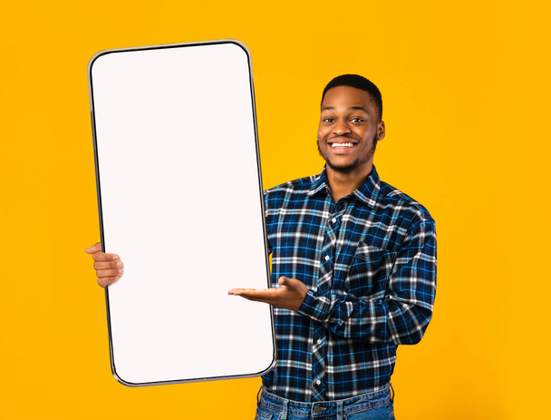 Musta kaveri osoittaa valkoista tyhjä älypuhelin näyttö - Valokuva, kuva