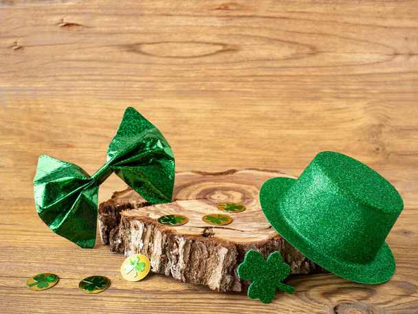 Kleeblatt und grüner Hut auf einem Holztisch, Symbol des irischen Feiertags St. Patricks Day. - Foto, Bild