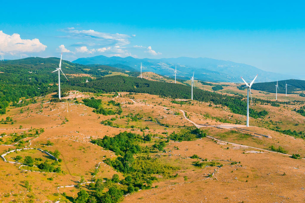 Αιολικά μηχανήματα παράγουν ανανεώσιμη ενέργεια κατά των βουνών - Φωτογραφία, εικόνα