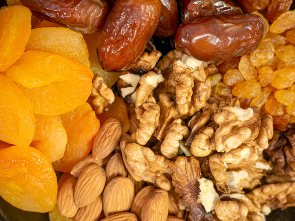 Орехи и сухофрукты. Орехи, миндаль, сушеные абрикосы, изюм и финики. Здоровое питание и закуски. Восточные сладости - Фото, изображение