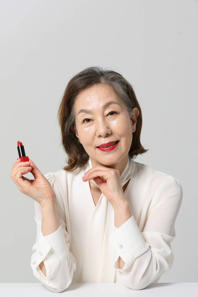 Asian Korean senior woman, bold and red cosmetics makeup beauty concept in studio - Photo, Image