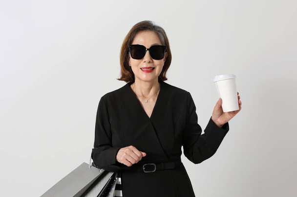 modne Azji koreański seniora kobieta trzyma a kawa i zakupy torba - Zdjęcie, obraz