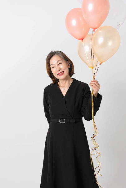 fashionable Asian Korean senior woman, holding a balloon - Foto, Imagem