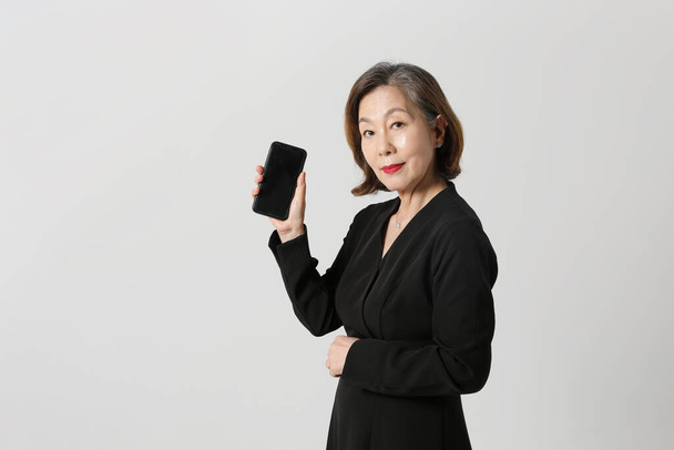 fashionable Asian Korean senior woman, holding a smartphone - 写真・画像
