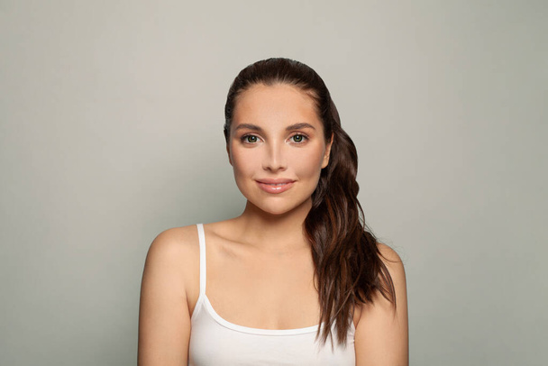 Cute brunette woman in a white shirt. Facial treatment, skin care, cosmetology, beauty and spa concept. - Foto, immagini