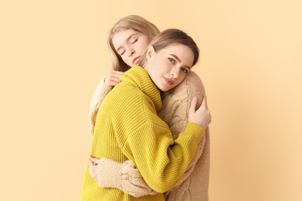 Portrait of hugging young sisters on color background - Photo, Image