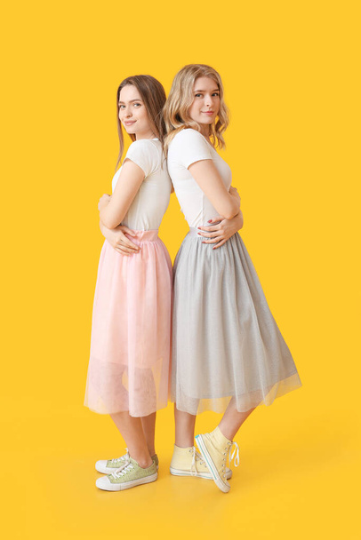 Portret młodszych sióstr na tle koloru - Zdjęcie, obraz