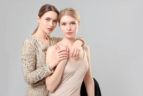 Retrato de hermanas jóvenes con estilo sobre fondo claro - Foto, imagen