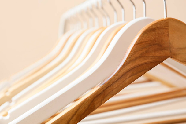 Rack with wooden clothes hangers on light background, closeup - Photo, Image
