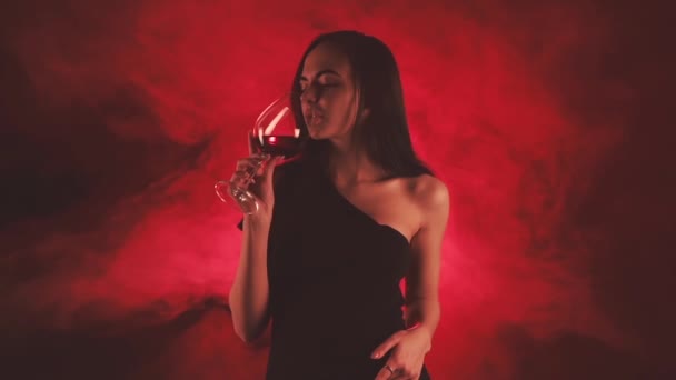 Nő egy pohár vörösborral vörös füstben - Felvétel, videó