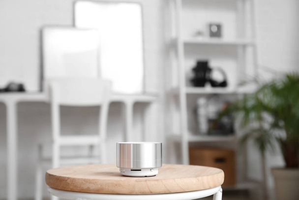 Altoparlante portatile senza fili su tavolo in legno in stanza luminosa - Foto, immagini
