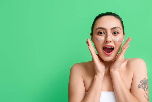 Emotionale Frau mit kreativem Make-up auf grünem Hintergrund - Foto, Bild