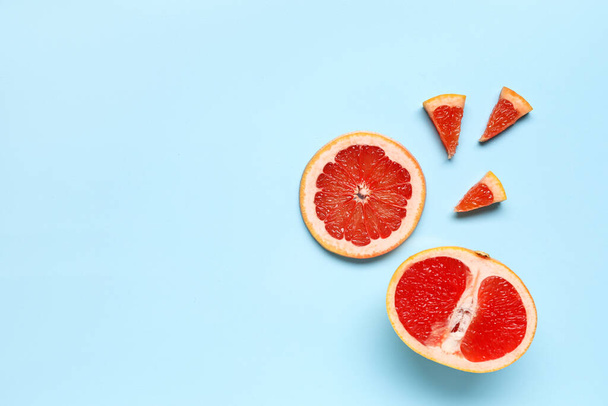 Slices of tasty ripe grapefruit on blue background - Фото, зображення