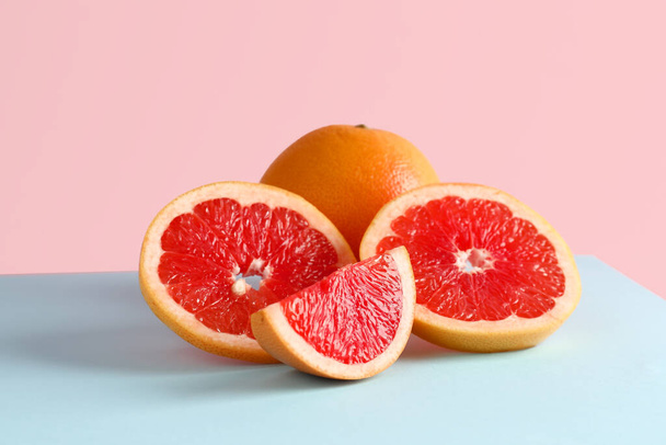 Tasty ripe grapefruits on pink background - Фото, зображення