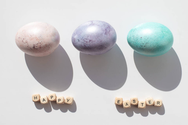 Húsvét koncepció. Rózsaszín, lila és kék tojás fehér háttérrel. Minimalizmus. Kemény árnyékok - Fotó, kép