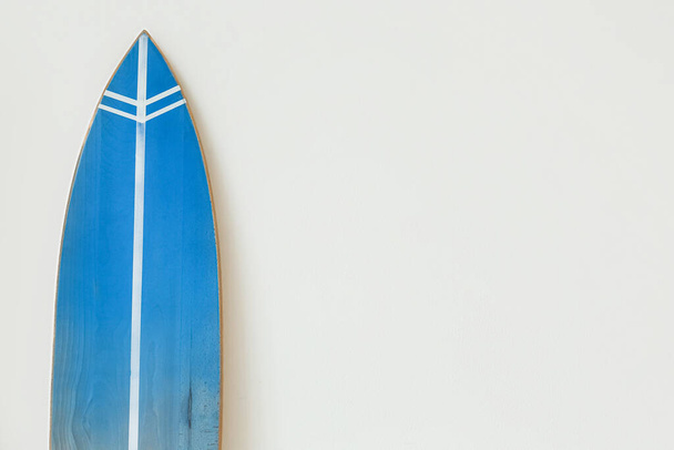 Голубая доска для серфинга у светлой стены - Фото, изображение
