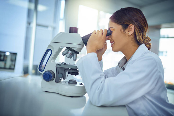 What a fascinating find we have here.... Shot of a young scientist using a microscope in a lab. - Foto, imagen