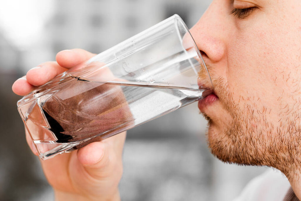 Close up man is drinking dirty water.  - 写真・画像