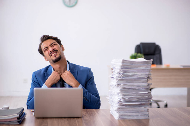 Jovem funcionário masculino infeliz com excesso de trabalho no escritório - Foto, Imagem