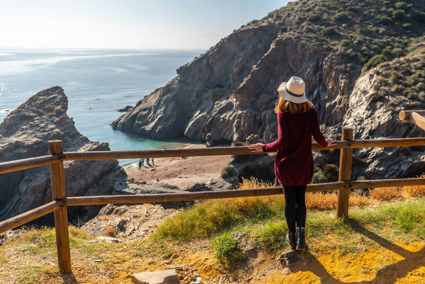 A young tourist girl looking at the beautiful Cala Peon cut off a virgin and hidden beach in Almeria. Mediterranean sea on the coast. Almanzora Caves, Almeria - Fotografie, Obrázek