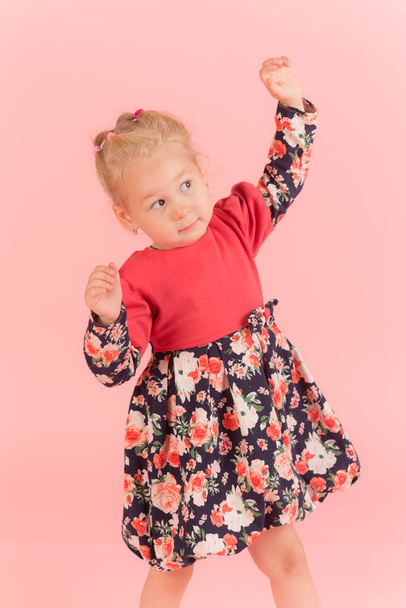 studio portrait of a little girl on a pink background - Foto, Bild