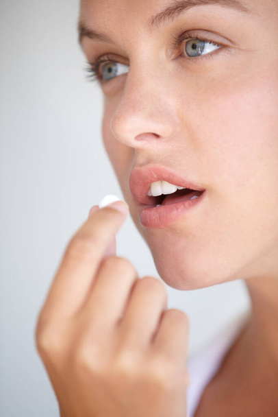 Morning meds. Closeup shot of a young woman taking a vitamin. - Фото, изображение